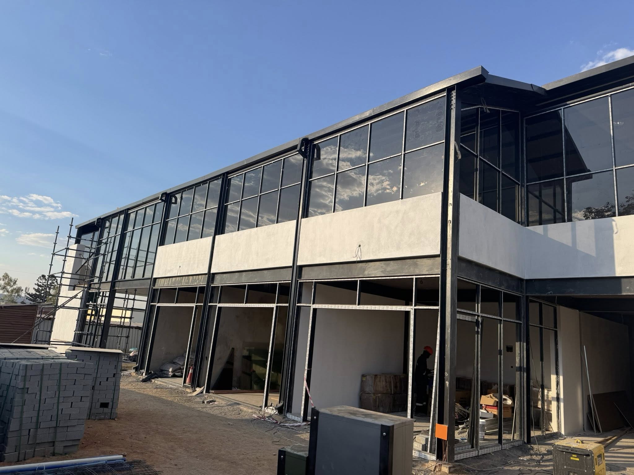 Steel Structures done by Pretoria Gates & Steel Structures Modern steel structure building with glass panels and commercial storefront constructed by Pretoria Gates And Steel Structures.